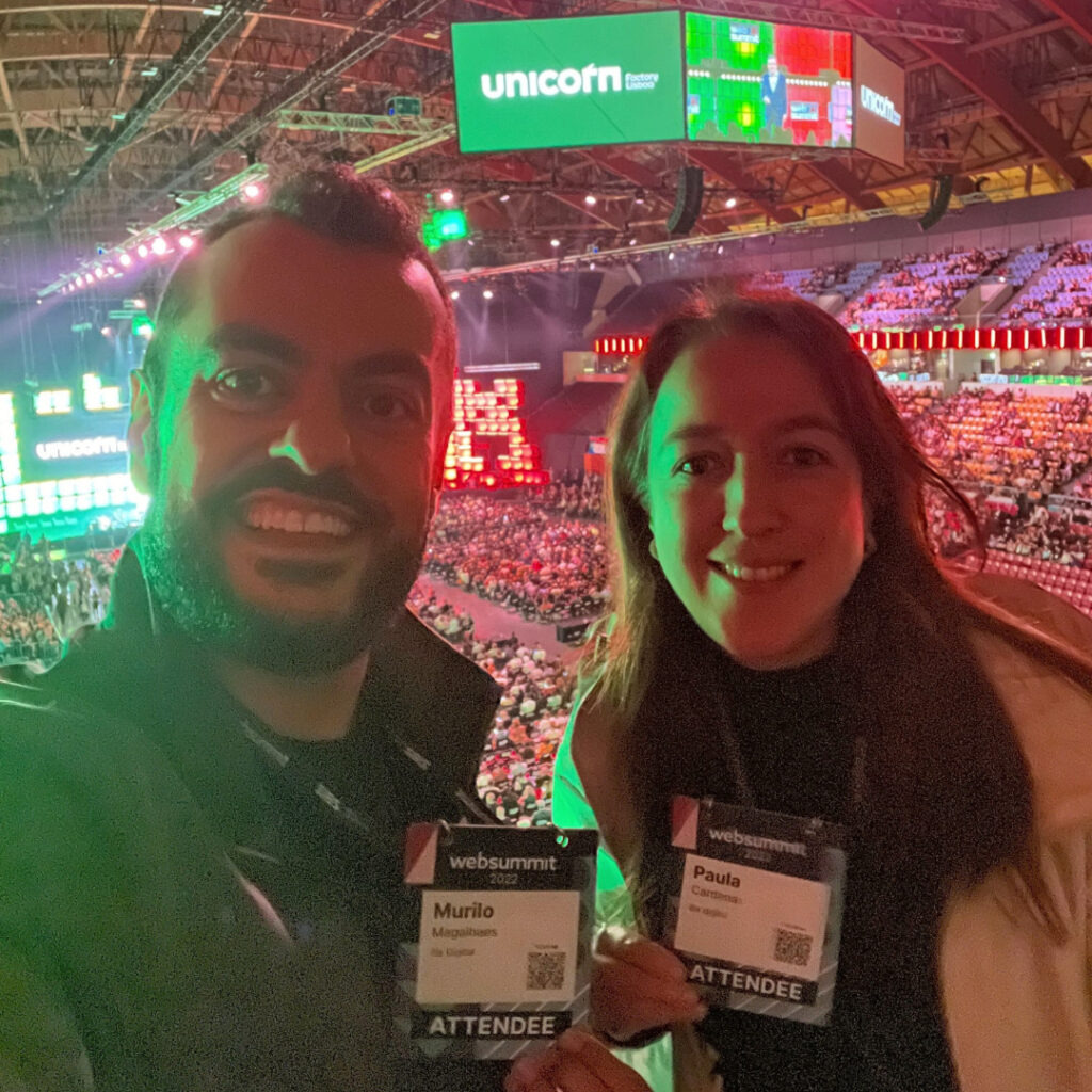 Paula Cárdenas, Gerente de Desenvolvimento de Negócios, e Murilo Magalhães, Head de Operações, representando a empresa no Web Summit Lisboa, participando de discussões sobre inovação e tecnologia.